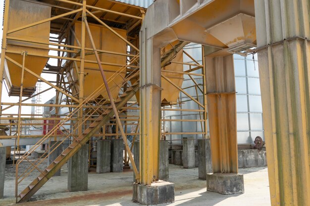 Silver silos on agro manufacturing plant for processing drying cleaning and storage of agricultural products flour cereals and grain Large iron barrels of grain Granary elevator