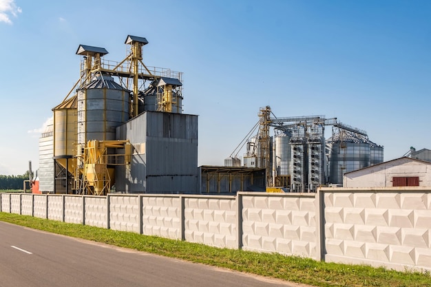 Silver silos on agroprocessing and manufacturing plant for processing drying cleaning and storage of agricultural products flour cereals and grain Granary elevator