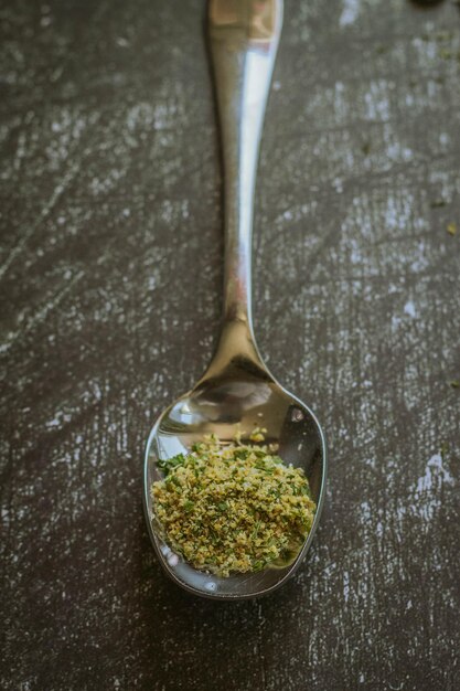 Photo a silver spoon with a sprinkle of seasoning on it.