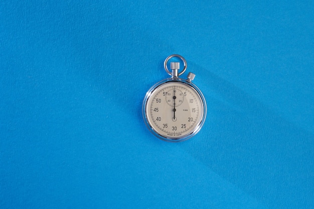 Silver stopwatch on blue background