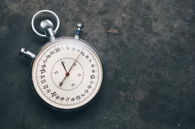 silver stopwatch on weathered background, including copy space. ideal for websites and magazines layouts