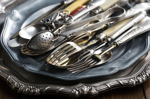 A silver tray with silverware on it and a silver fork on it.