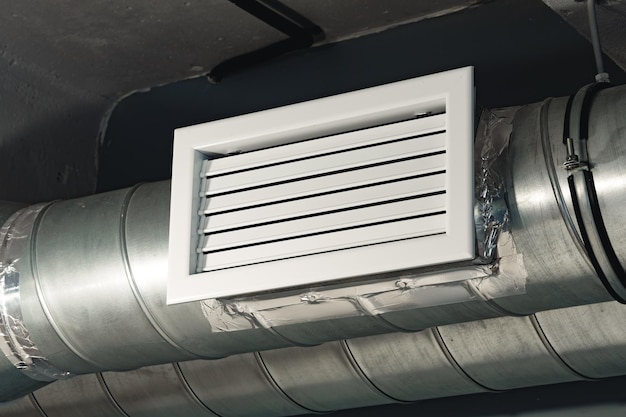 Silver ventilation pipes hanging from the ceiling inside the building