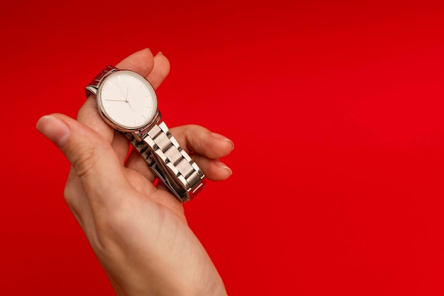Silver watch on a bright red background