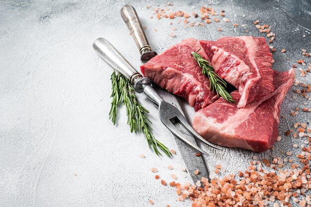 Silverside sirloin beef cut raw meat on butcher table with herbs White background Top view Copy space