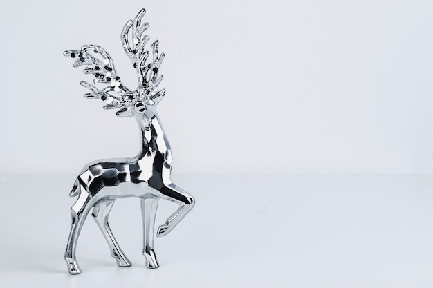 Silvery figurine of a deer on a gray background