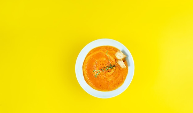 Photo simmer cold cream soup gazpacho on a yellow table