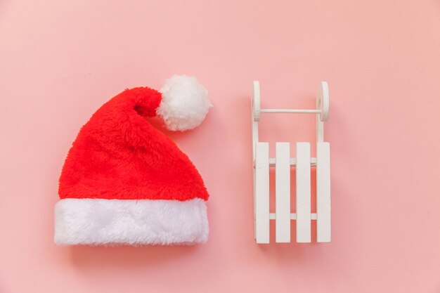 Simpel minimale samenstelling Kerst Santa Claus hoed slee geïsoleerd op roze pastel