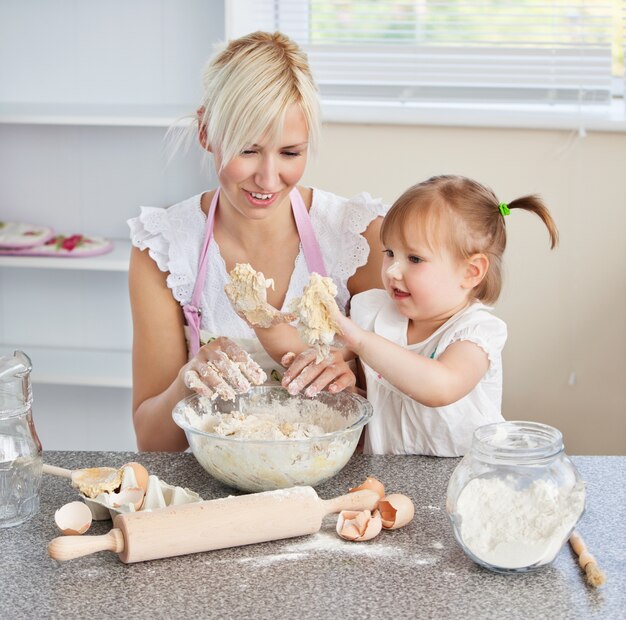 Simper woman baking cookies with her daughter