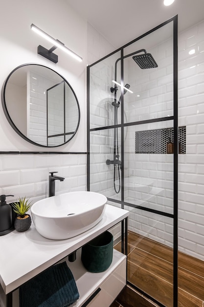 Simple bathroom with black shower round mirror and classic white tiles