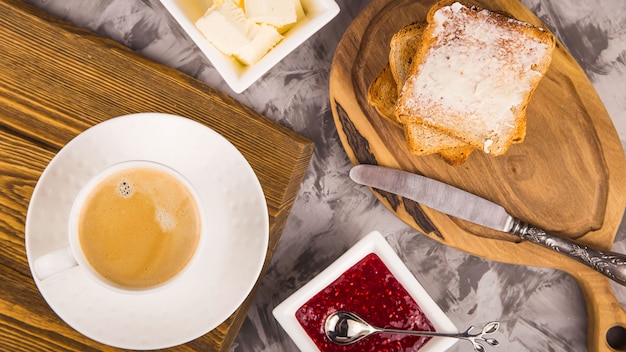 Simple breakfast of traditional products - toast with butter and raspberry jam