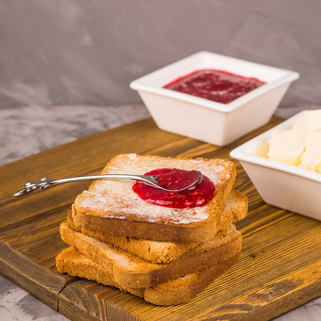 Simple breakfast of traditional products - toast with butter and raspberry jam