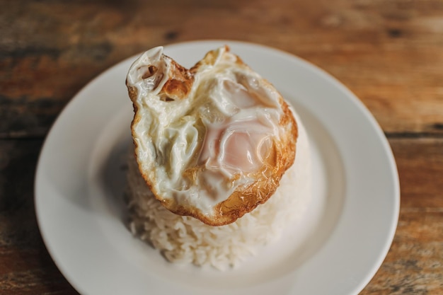 Simple food menu of Thai rice and fried egg on table