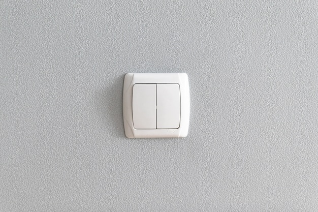 Photo simple light switch on grey wall.