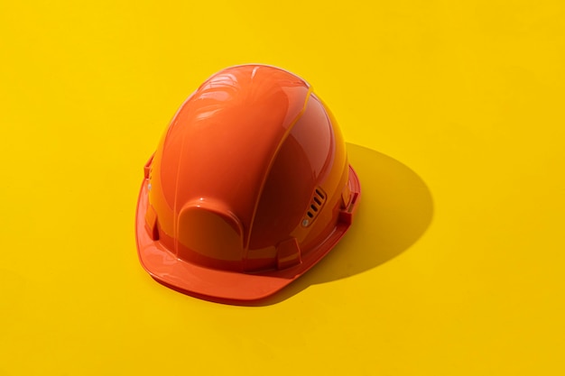 A the simple orange head helmet, abstract minimalistic concept of the safety job