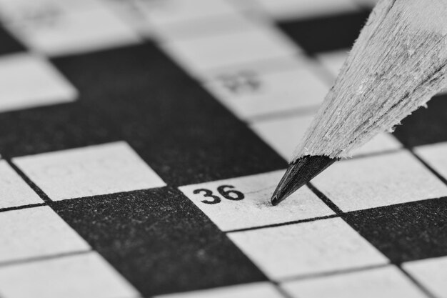 Photo simple pencil on background of crossword puzzle closeup