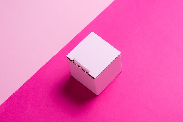 Photo simple pink cardboard box on color background, top view