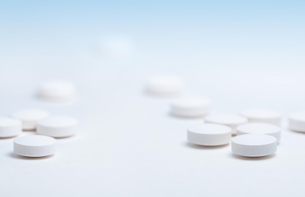 Простые простые белые таблетки куча таблеток сложены на белом фоне