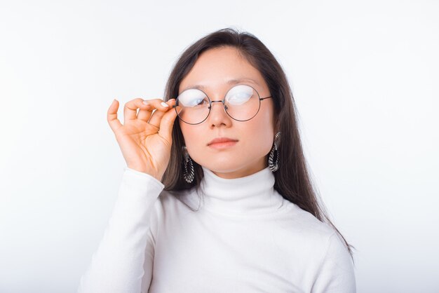 Simple portrait of a young pretty girl wearing round glasses on white space.