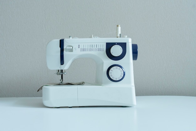 Simple sewing machine on the shelf against the wall isolated home supplies