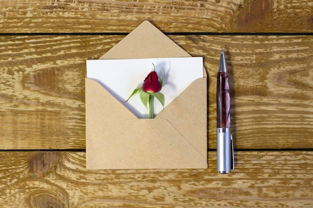 Простой маленький конверт с местом для письма на деревянном фоне с ручкой Узкая линия фокусировки малая глубина резкости