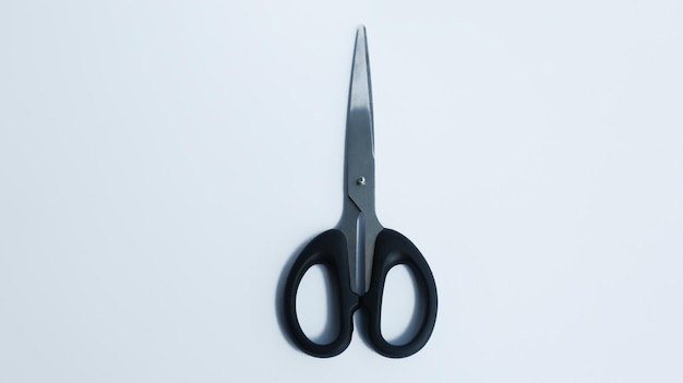 Simple stainless steel with black handler scissor isolated on white