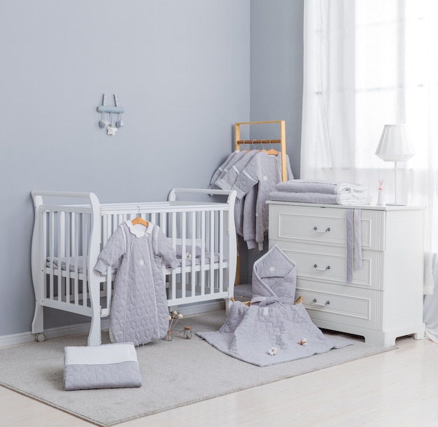 Simple, white baby bedroom with cot and rug