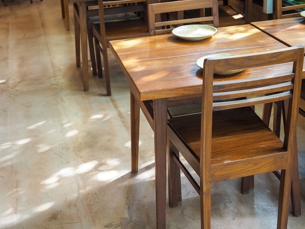 Simple wooden dining table with empty dish and wood chairs