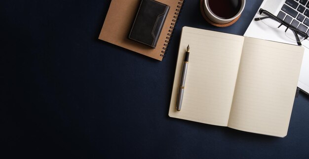 Simple working desk with laptop computer coffee cup notebook and table Top view with copy space