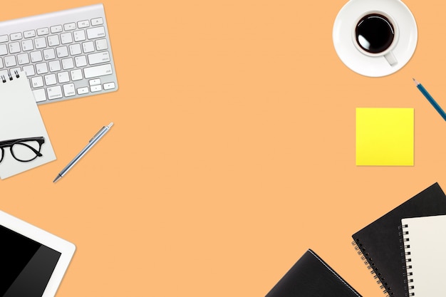 simple workspace technology orange table with laptop computer, coffee cup notebook and copy space 