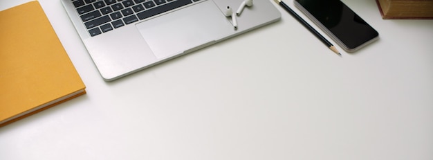 Simple worktable with digital device, stationery and copy space on white desk