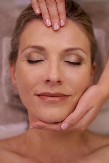 Photo simply blissful cropped shot of a woman in a day spa getting a face massage