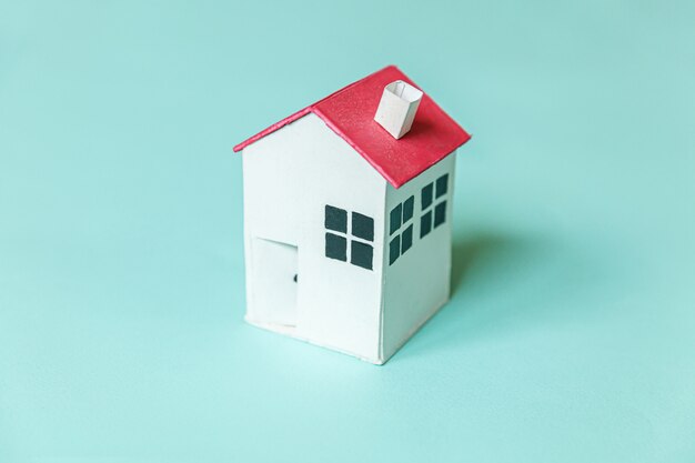 Simply design with miniature white toy house isolated on blue pastel