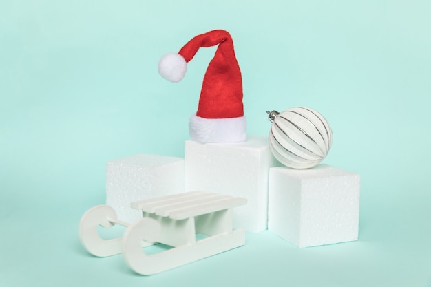 Semplicemente composizione minimale oggetti invernali ornamento e forme cubiche forma geometrica podio isolato sfondo blu pastello. natale capodanno dicembre per il concetto di celebrazione. mockup, copia spazio