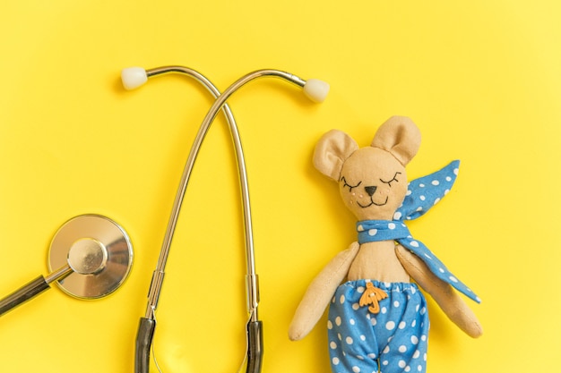 Photo simply minimal design toy bear and stethoscope isolated on yellow background