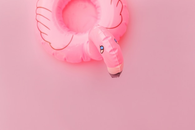 Simply minimal design with Inflatable flamingo isolated on pastel pink background.