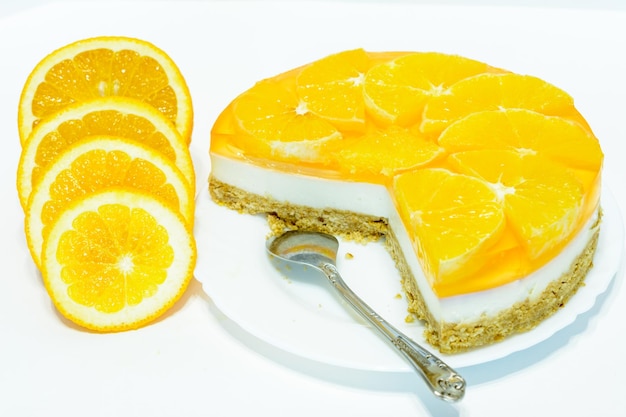 sinaasappel cheesecake met theelepel en schijfjes sinaasappelfruit