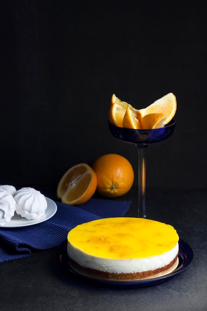 Sinaasappelcake met roommousse en sinaasappelgelei op donkere achtergrond