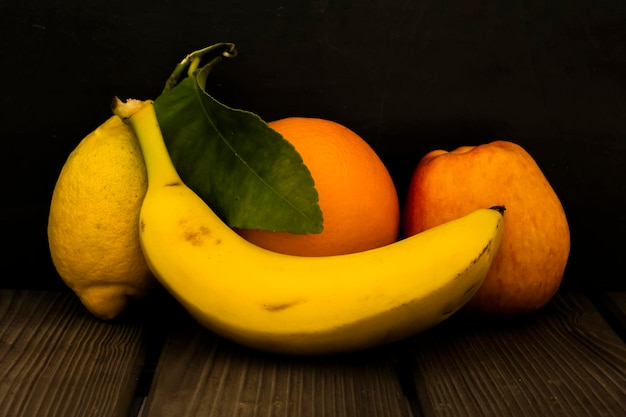 Sinaasappelen bananen en citroen over een houten tafel