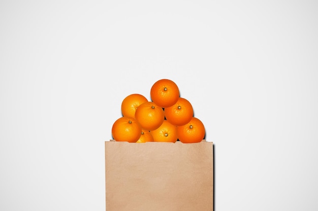 Sinaasappelen in een papieren zak op een lichte achtergrond