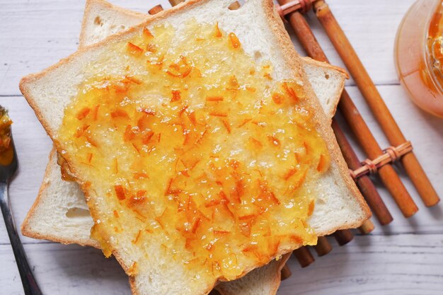 Sinaasappelfruit verspreid over een brood op tafel