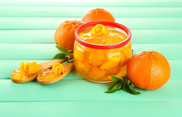 Sinaasappeljam met schil en mandarijnen op houten bureau op houten tafel