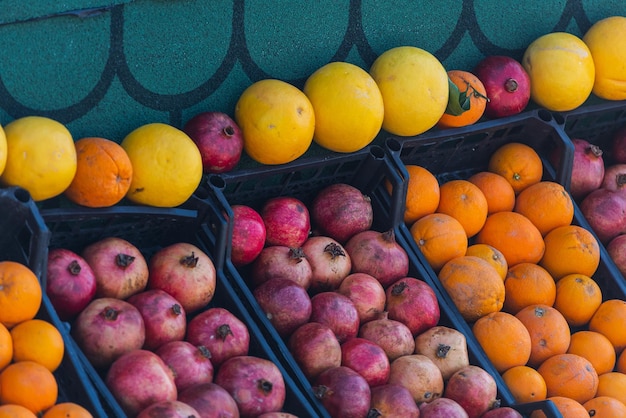 Sinaasappels en druiven op de achtergrond van de doos Verse sinaasappelen die in de winkel worden gekweekt, sinaasappels die geschikt zijn voor sap, strudel, sinaasappelpuree, compote