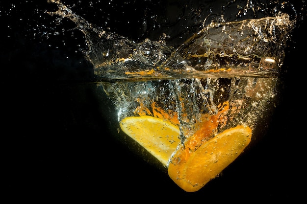 Sinaasappelschijfjes vallen in het water