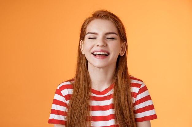 Sincere happy charismatic redhead girl smiling close eyes enjoy warm summer sunbeams laughing cheerf...