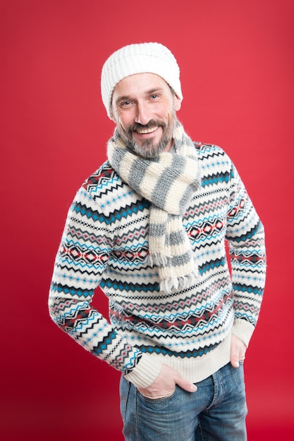 Sincere smile. Handsome bearded man wearing hat and scarf. Winter fashion. Knitted accessories. Winter weather style. Menswear concept. Fashion collection. Fashion clothes. Cold winter conditions.