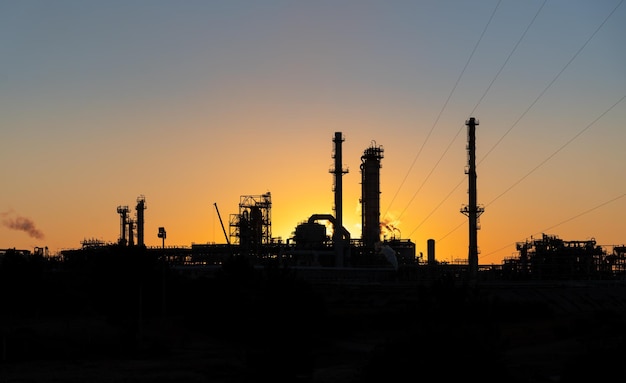 Sines refinery, Portugal at sunset with chimneys giving off flames and smoke