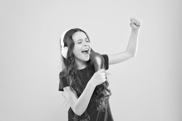 Sing lyrics Child teen enjoy music playing in earphones Little girl enjoying favorite music Catch the rhythm Kid listening music headphones Entertainment and fun Whole musical world in her ears