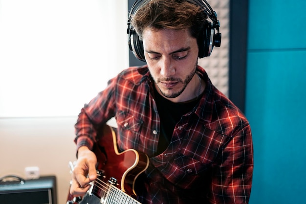 Photo singer playing guitar at studio