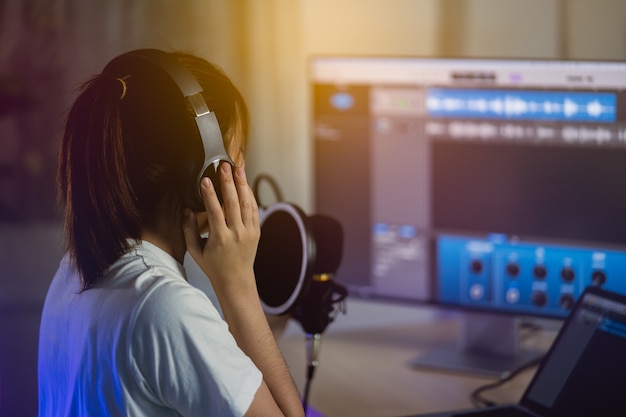 Donne cantanti che cantano con le cuffie registrano una nuova canzone nello studio di registrazione di casa